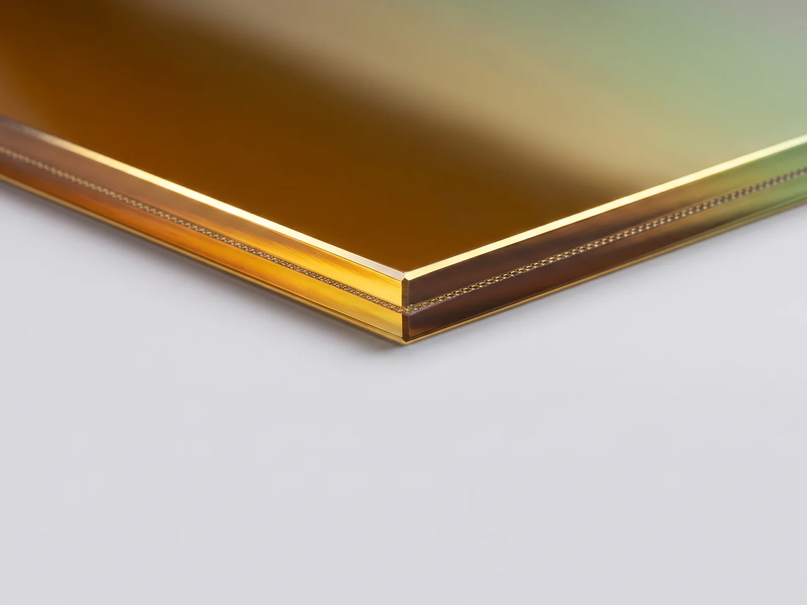 Macro del canto pulido de un vidrio laminado tornasol, con el inserto de malla visible entre las capas de EVA